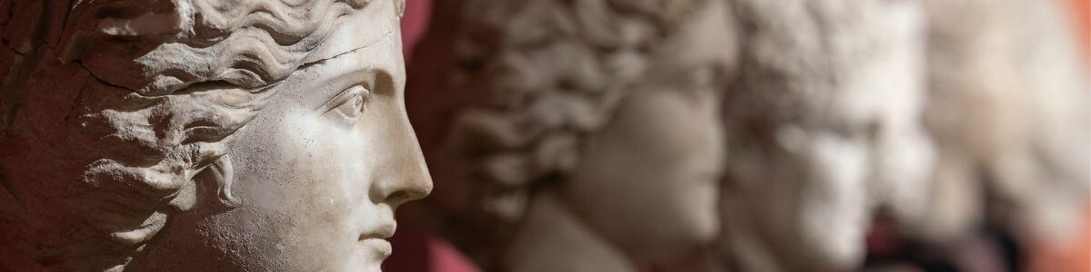 A row of statues, with only one face in focus, showcasing attention and concentration.
